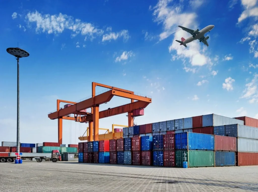 Shipping containers and gantry crane, airplane overhead