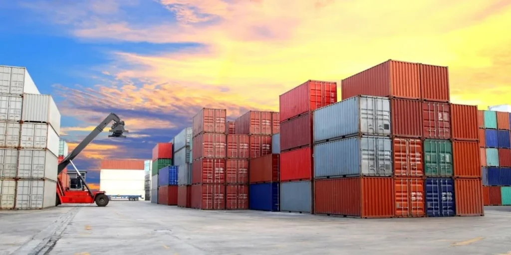 Colorful stacked shipping containers at sunset
