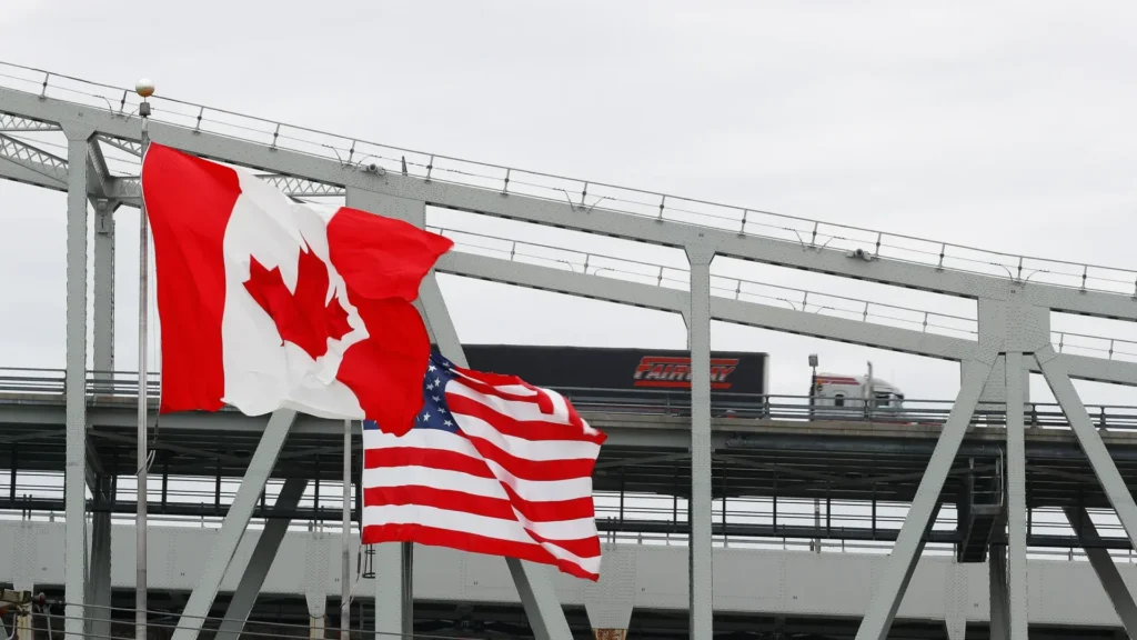 Canadian and American flags on bridge