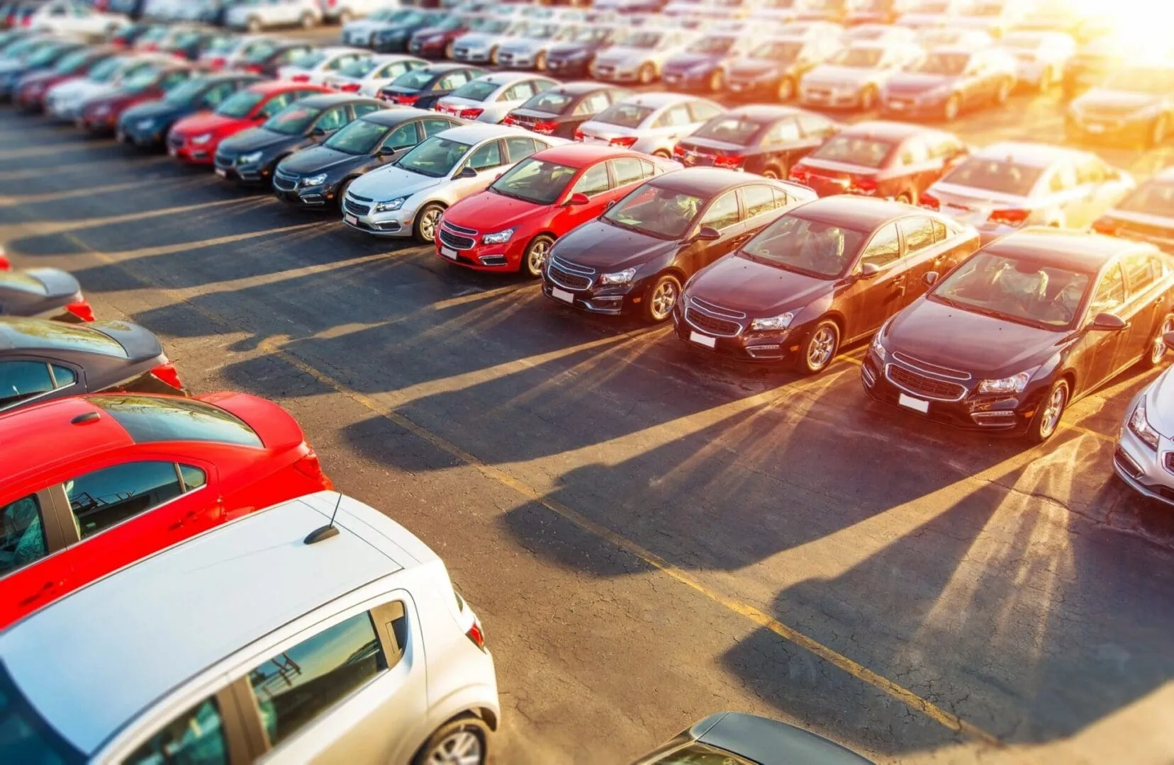 Rows of new cars parked in dealership lot