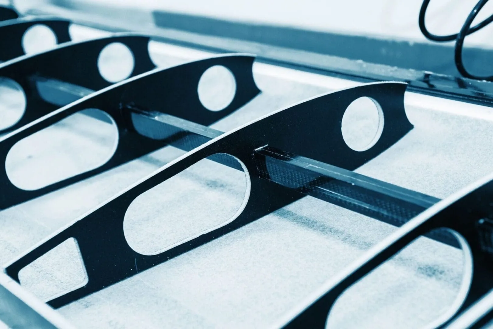 Black metal brackets with oval cutouts closeup