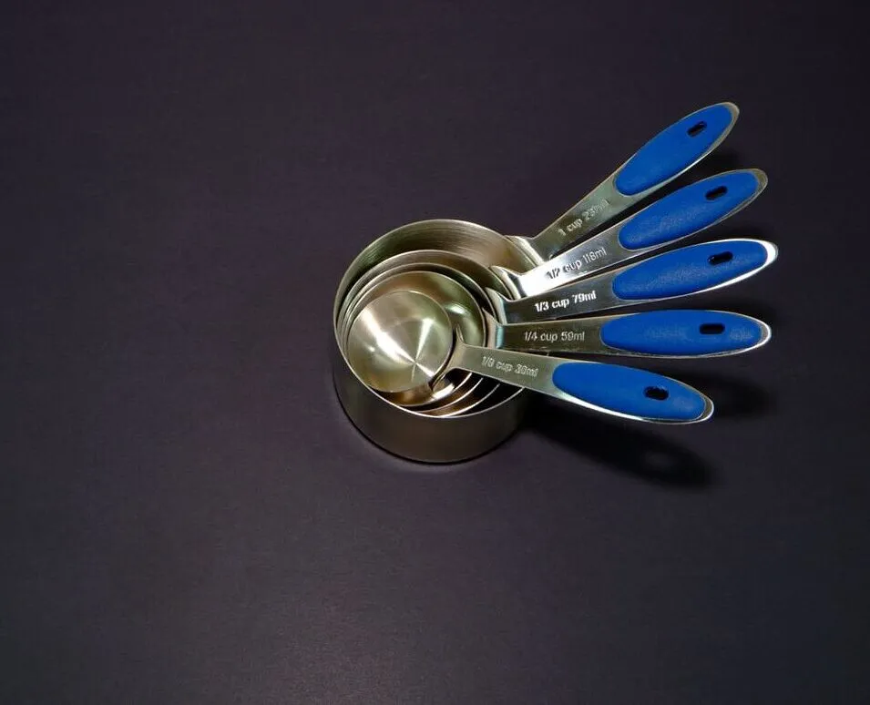 Stacked stainless steel measuring cups with blue handles