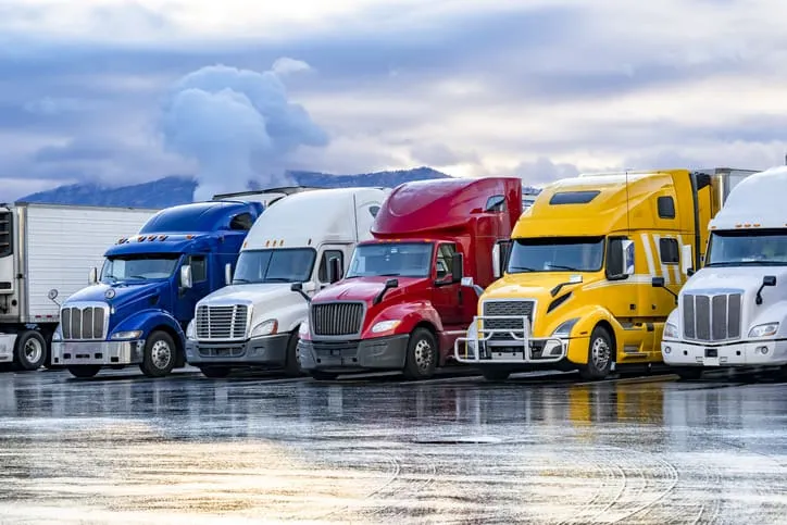 Row of colorful semi trucks in parking lot